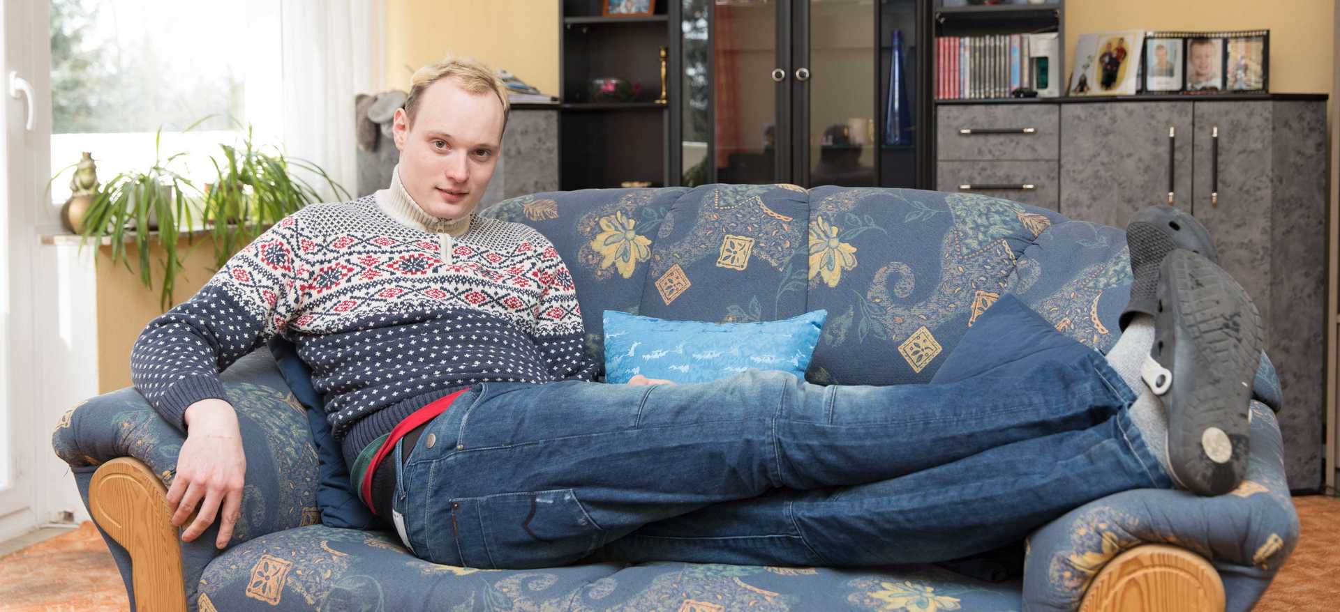 Ein junger Mann liegt bequem auf dem Sofa